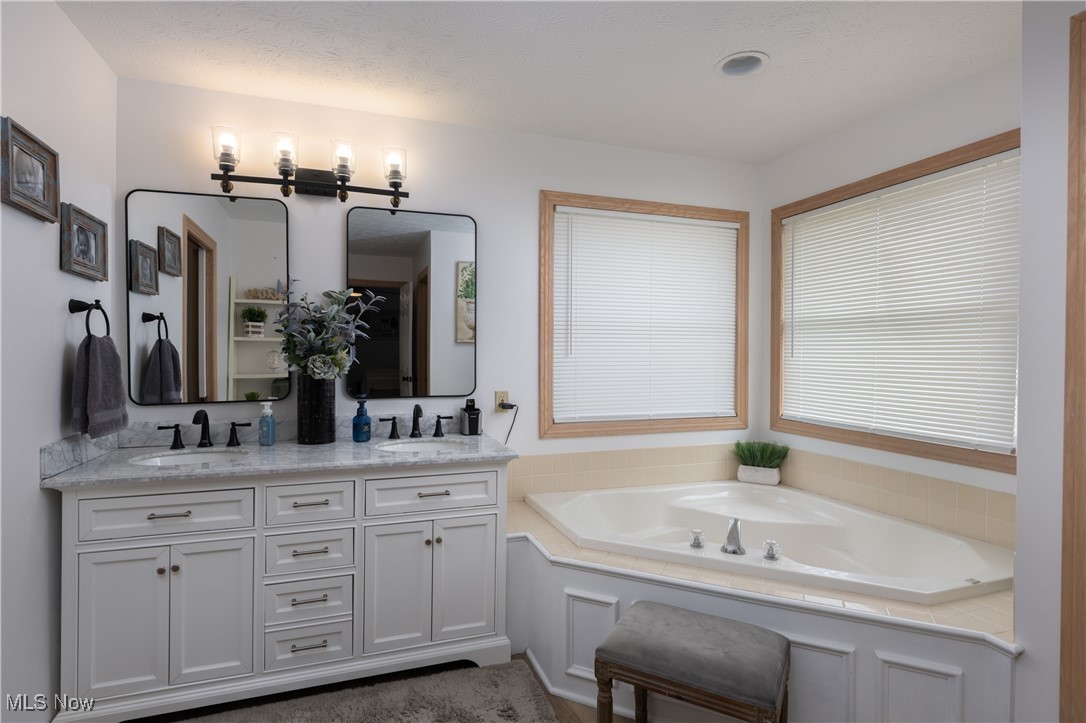 847 Lockwood Road Barberton, OH 44203 - Photo 16 of 29 Full bath featuring double vanity, a garden tub, and a sink