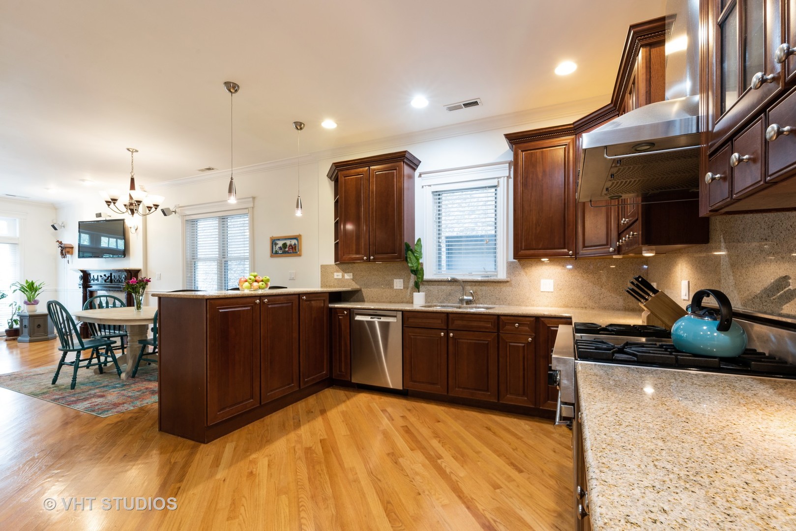 3535 North Reta Avenue, Unit 3 Chicago, IL 60657 - Photo 5 of 18 a kitchen with stainless steel appliances granite countertop a refrigerator a stove a sink and a dining table with wooden floor