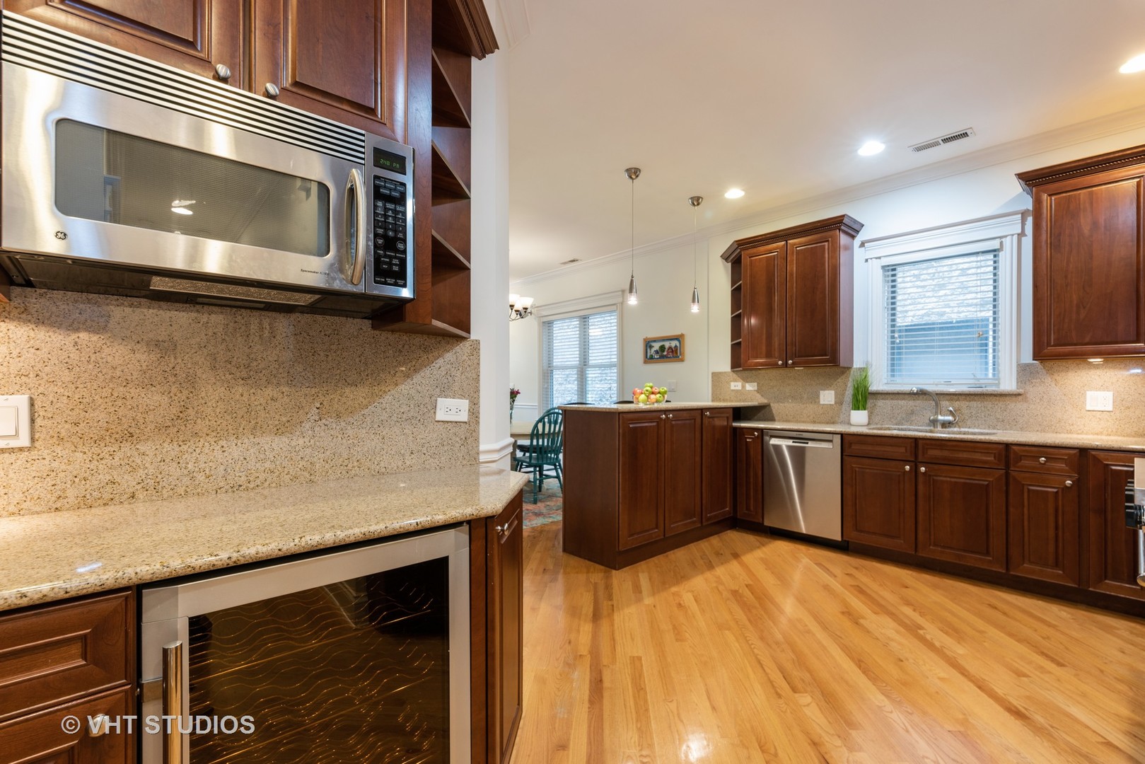3535 North Reta Avenue, Unit 3 Chicago, IL 60657 - Photo 7 of 18 a kitchen with stainless steel appliances kitchen island granite countertop a stove a sink and a microwave