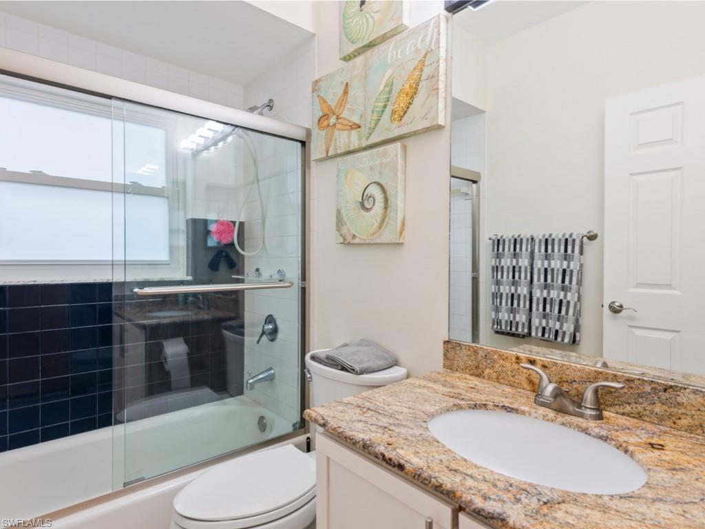181 Napa Ridge Road East, Unit 35 Naples, FL 34119 - Photo 12 of 17 a bathroom with a granite countertop toilet sink and mirror
