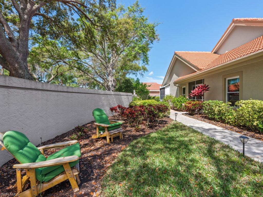 181 Napa Ridge Road East, Unit 35 Naples, FL 34119 - Photo 14 of 17 a backyard of a house with table and chairs