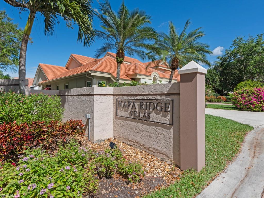 181 Napa Ridge Road East, Unit 35 Naples, FL 34119 - Photo 2 of 17 a sign that is on the side of the grass