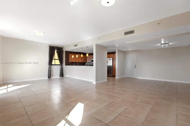 a view of a livingroom with a flesh screen tv and windows