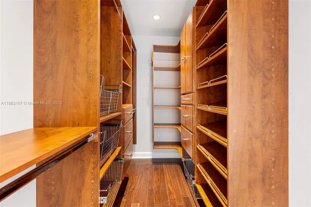 a view of walk in closet with clothes and shoes