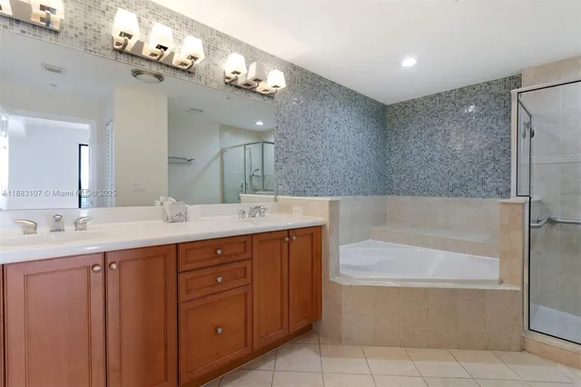 a bathroom with a tub a sink double vanity and a mirror