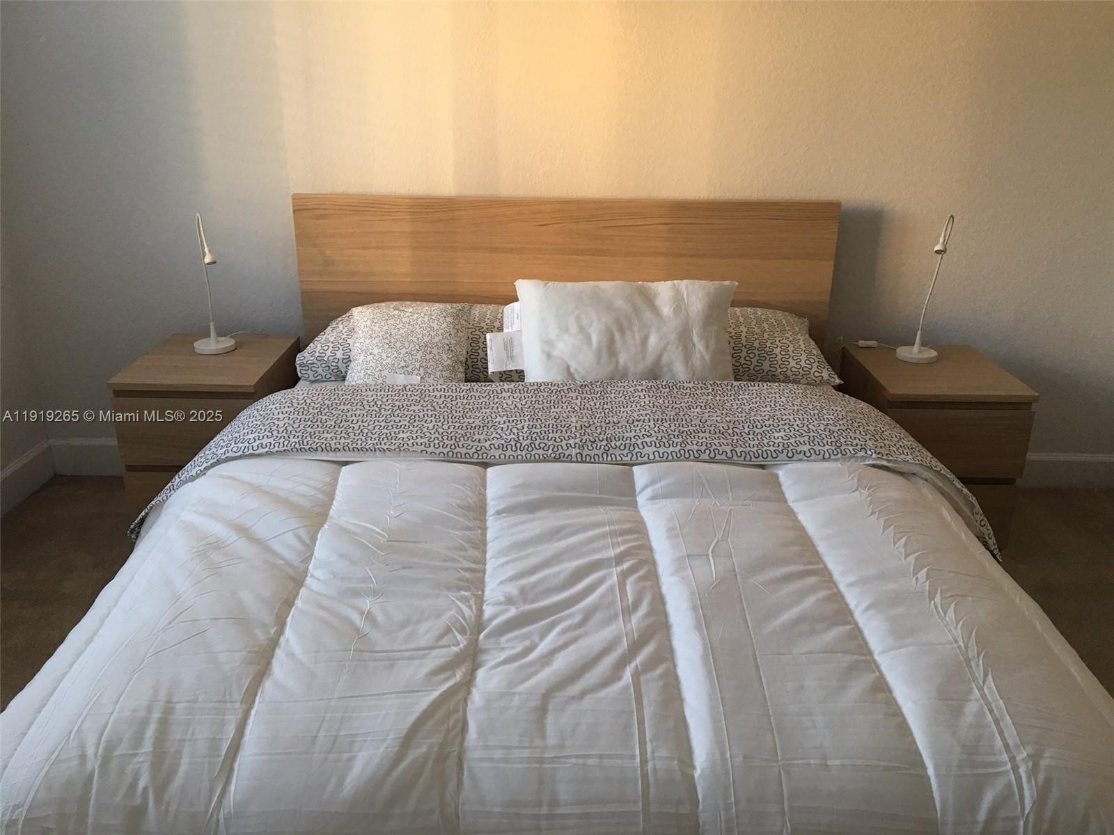 6001 Southwest 70th Street, Unit 525 South Miami, FL 33143 - Photo 6 of 14 a bedroom with a bed and night stand