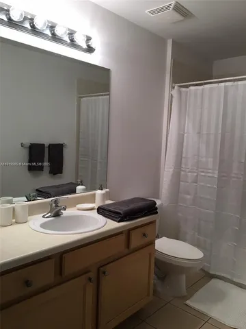 a bathroom with a sink a toilet a mirror and shower
