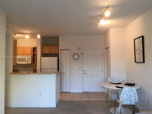 a view of a hallway with bathroom and a mirror