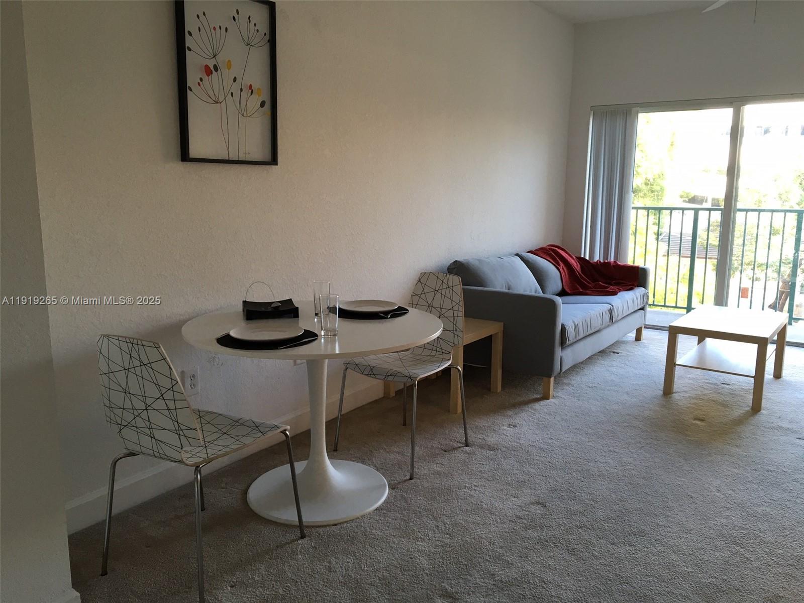 6001 Southwest 70th Street, Unit 525 South Miami, FL 33143 - Photo 10 of 14 a living room with furniture and a floor to ceiling window