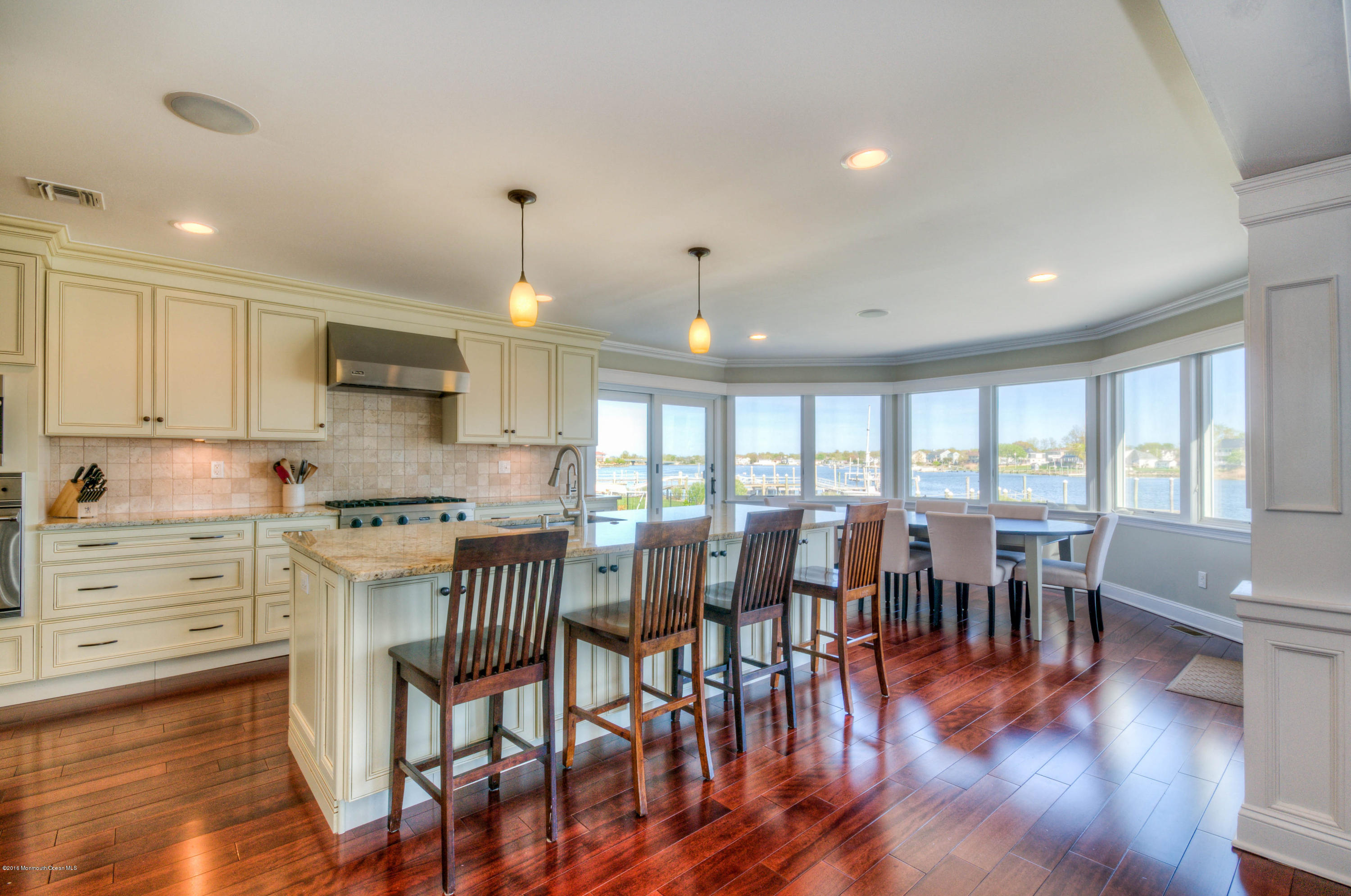 68 Rivers Edge Drive Little Silver, NJ 07739 - Photo 4 of 25 a kitchen with stainless steel appliances granite countertop a stove top oven a dining table and chairs with wooden floor