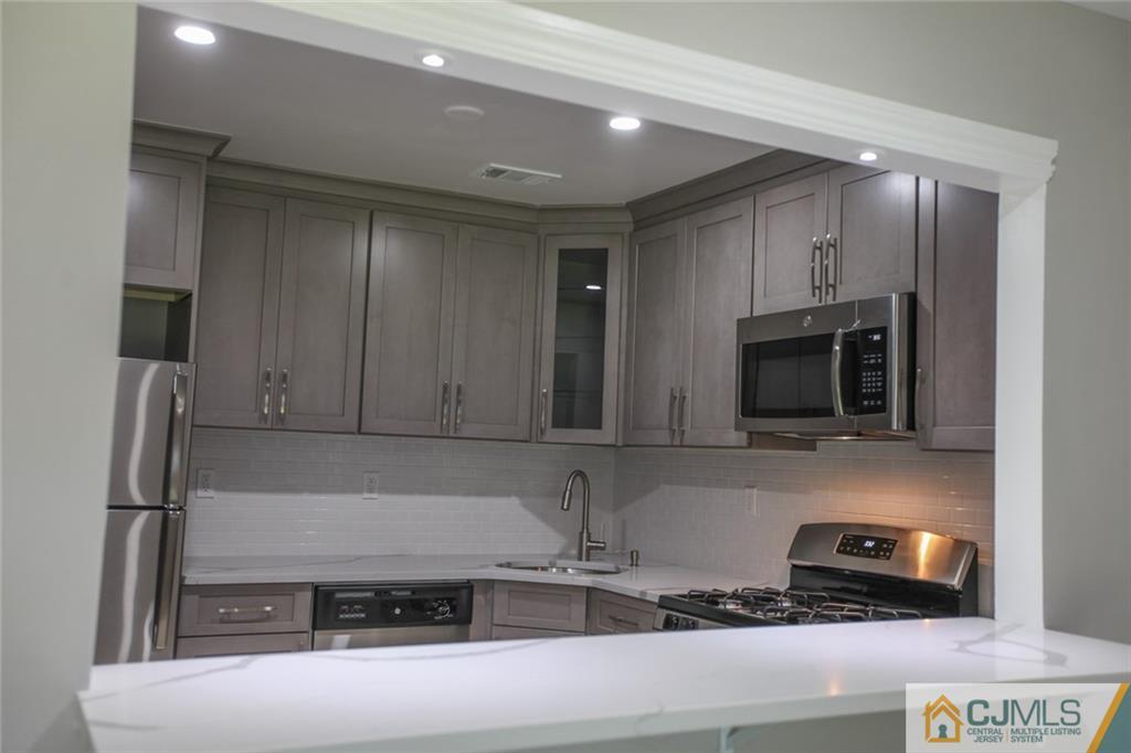 3002 Hana Road Edison, NJ 08817 - Photo 4 of 15 a kitchen with stainless steel appliances granite countertop a refrigerator and a stove top oven