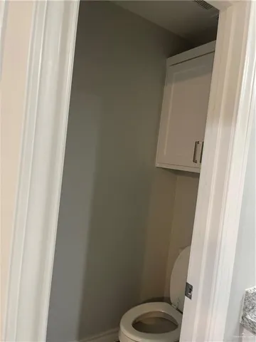 a white toilet sitting next to a shower