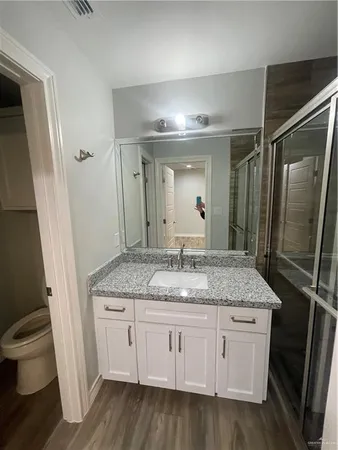 a bathroom with a granite countertop sink toilet and shower
