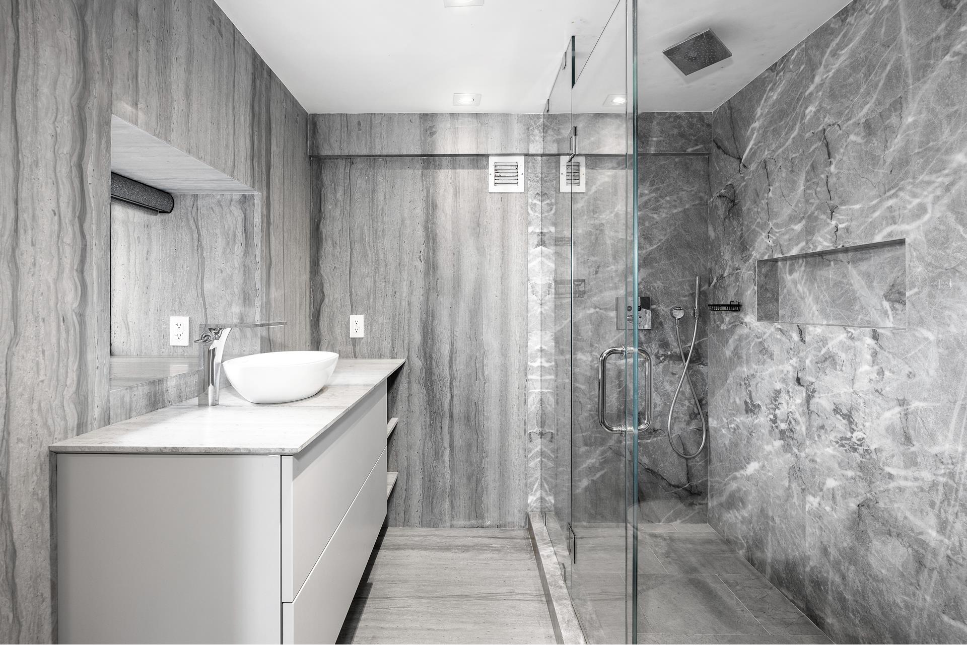 135 West 70th Street, Unit 10C Manhattan, NY 10023 - Photo 19 of 24 a bathroom with a granite countertop shower sink and mirror