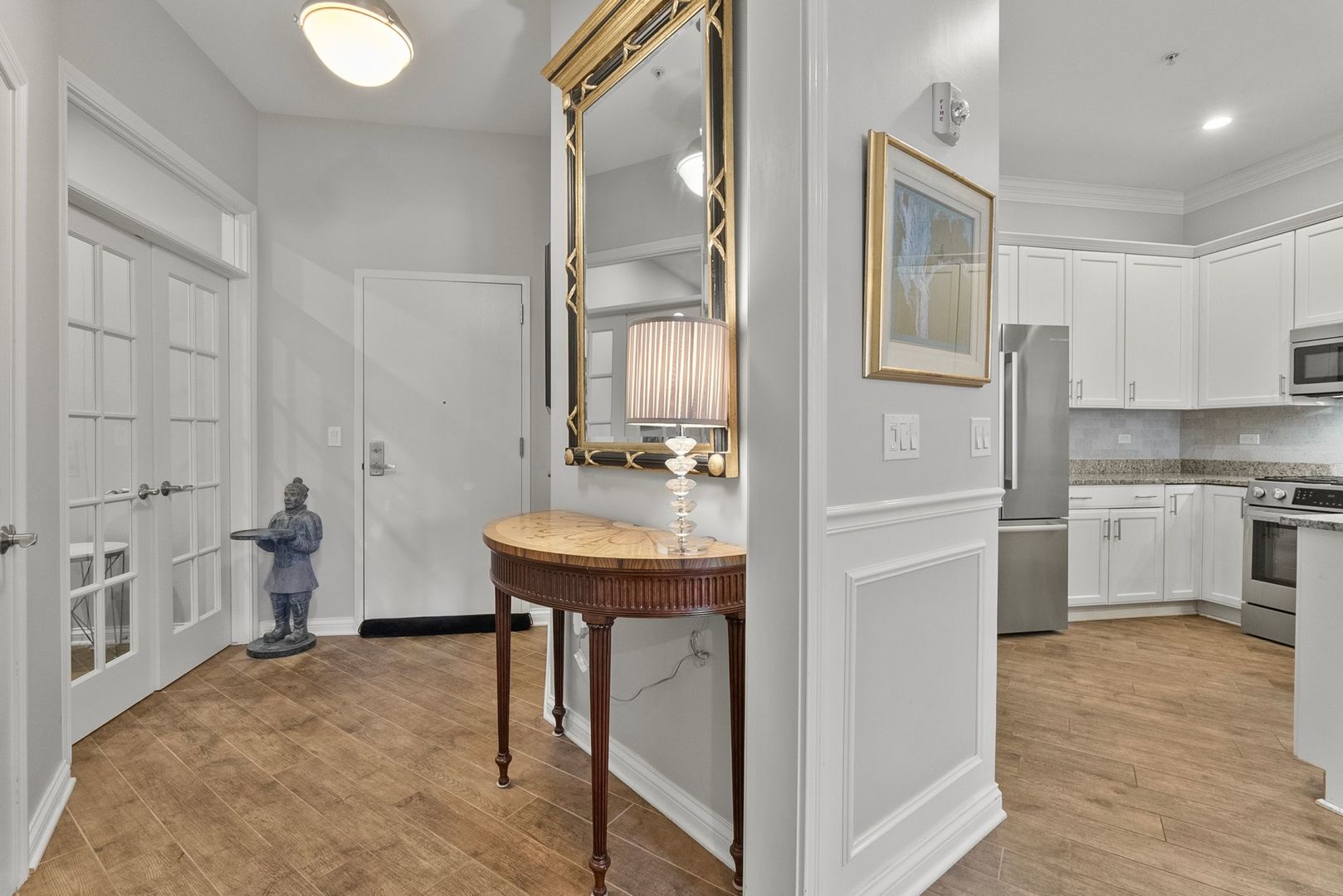 1000 Village Center Drive, Unit 102 Burr Ridge, IL 60527 - Photo 4 of 28 a kitchen with white cabinets and stainless steel appliances