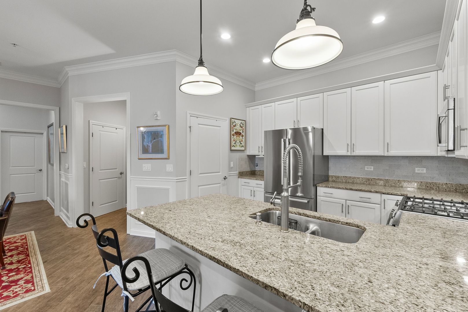 1000 Village Center Drive, Unit 102 Burr Ridge, IL 60527 - Photo 7 of 28 a kitchen with kitchen island granite countertop a sink cabinets and stainless steel appliances