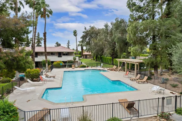 a view of a patio with couches table and chairs and potted plants