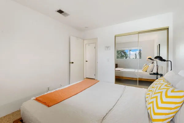 a bedroom with a bed and a mirror