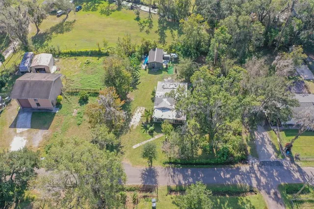 an aerial view of a house with a yard and lake view