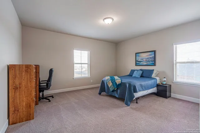 a living room with furniture a flat screen tv and a refrigerator