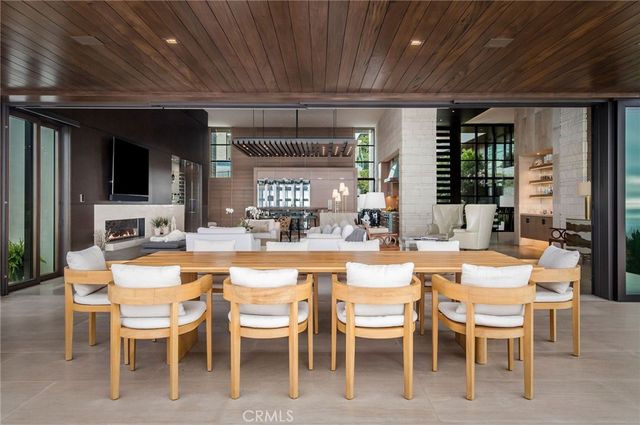 a dining hall with stainless steel appliances kitchen island granite countertop furniture and a large window