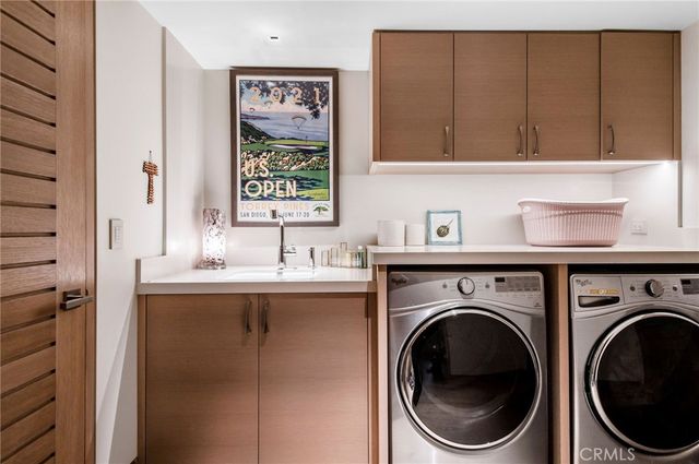 a utility room with sink dryer and washer