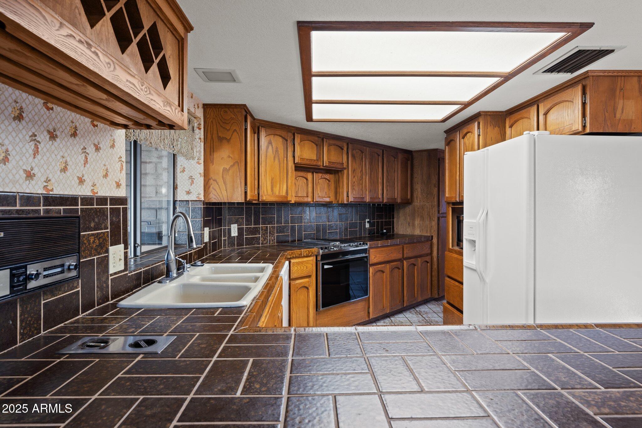 27610 Gill Road Morristown, AZ 85342 - Photo 8 of 71 a kitchen with stainless steel appliances granite countertop a stove a sink and a microwave