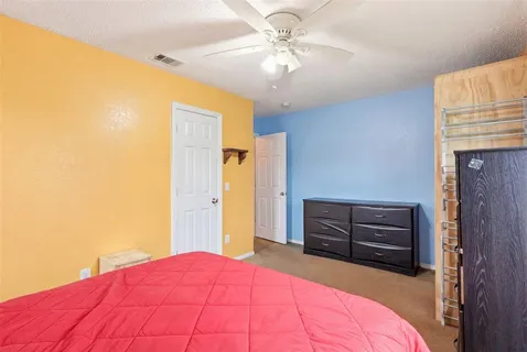 a bedroom with a bed dresser and a window