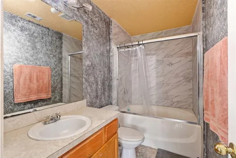 a bathroom with a granite countertop sink toilet and shower