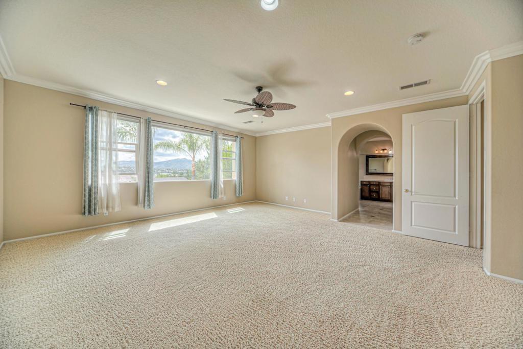 32215 Vía Bejarano Temecula, CA 92592 - Photo 20 of 42 an empty room with windows and ceiling fan