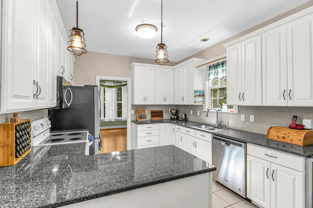a kitchen with stainless steel appliances granite countertop a stove top oven a refrigerator a sink and dishwasher