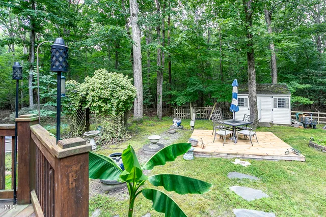 a patio with wooden floor a yard tables and chairs