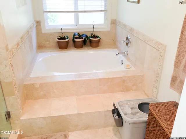 a bathroom with a tub sink and mirror