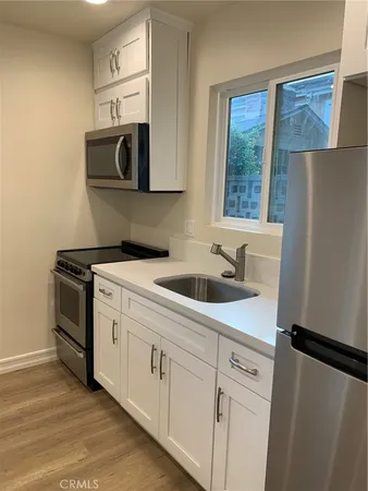 a kitchen with stainless steel appliances a refrigerator sink and microwave