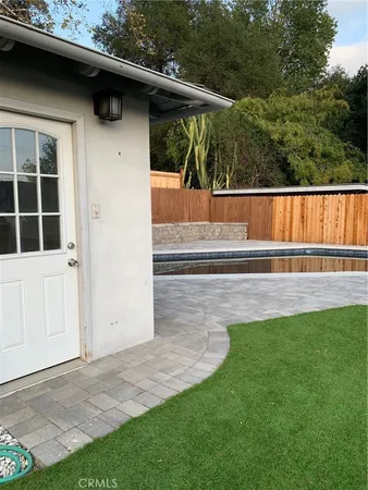 a view of backyard with small cabin and wooden fence