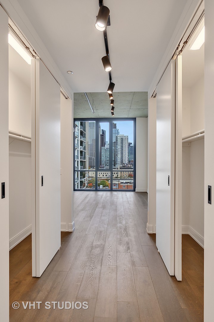 111 South Peoria Street, Unit 804 Chicago, IL 60607 - Photo 20 of 33 a view of a hallway with wooden floor and chandelier