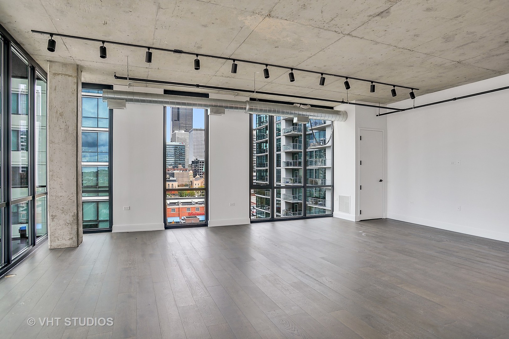 111 South Peoria Street, Unit 804 Chicago, IL 60607 - Photo 3 of 33 an empty room with wooden floor and windows