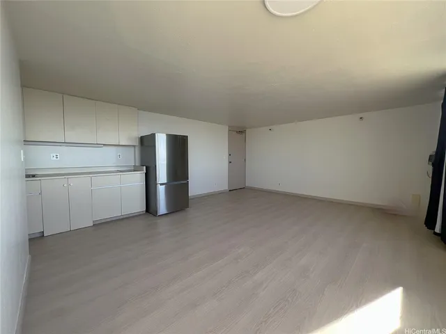 a view of an empty room with a kitchen