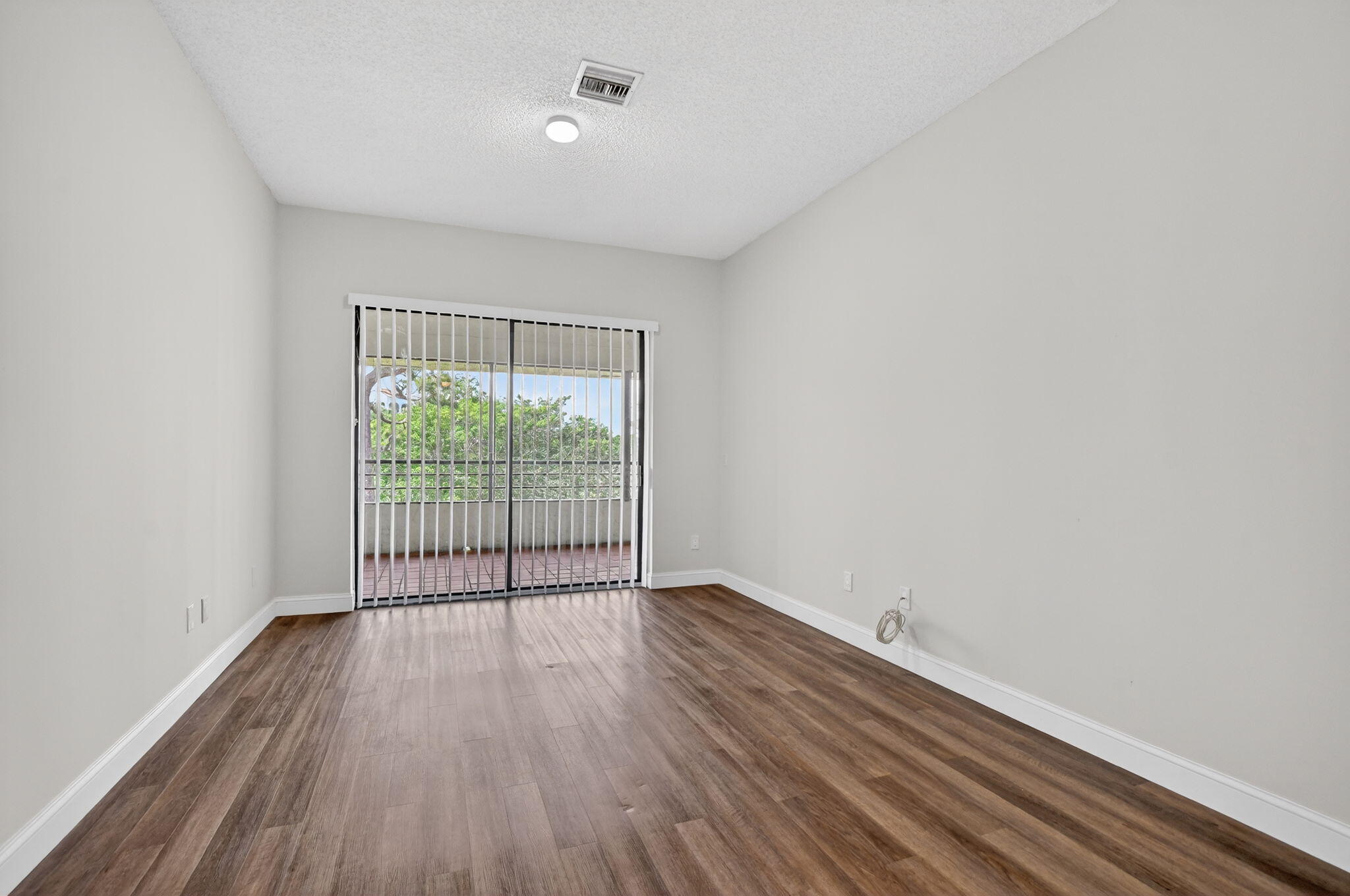 7472 La Paz Boulevard, Unit 304 Boca Raton, FL 33433 - Photo 16 of 36 wooden floor in an empty room with a window