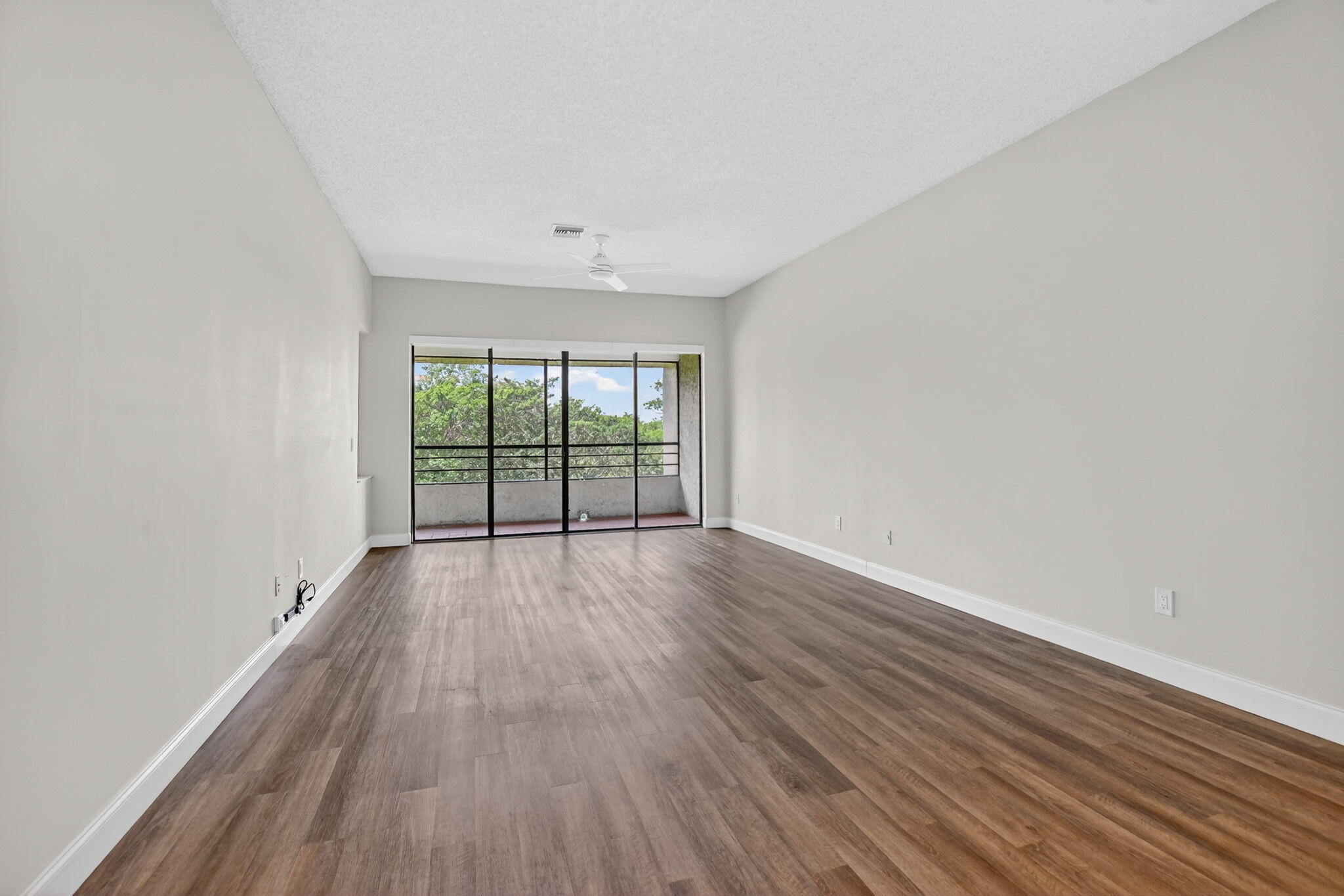 7472 La Paz Boulevard, Unit 304 Boca Raton, FL 33433 - Photo 6 of 36 wooden floor in an empty room with a window