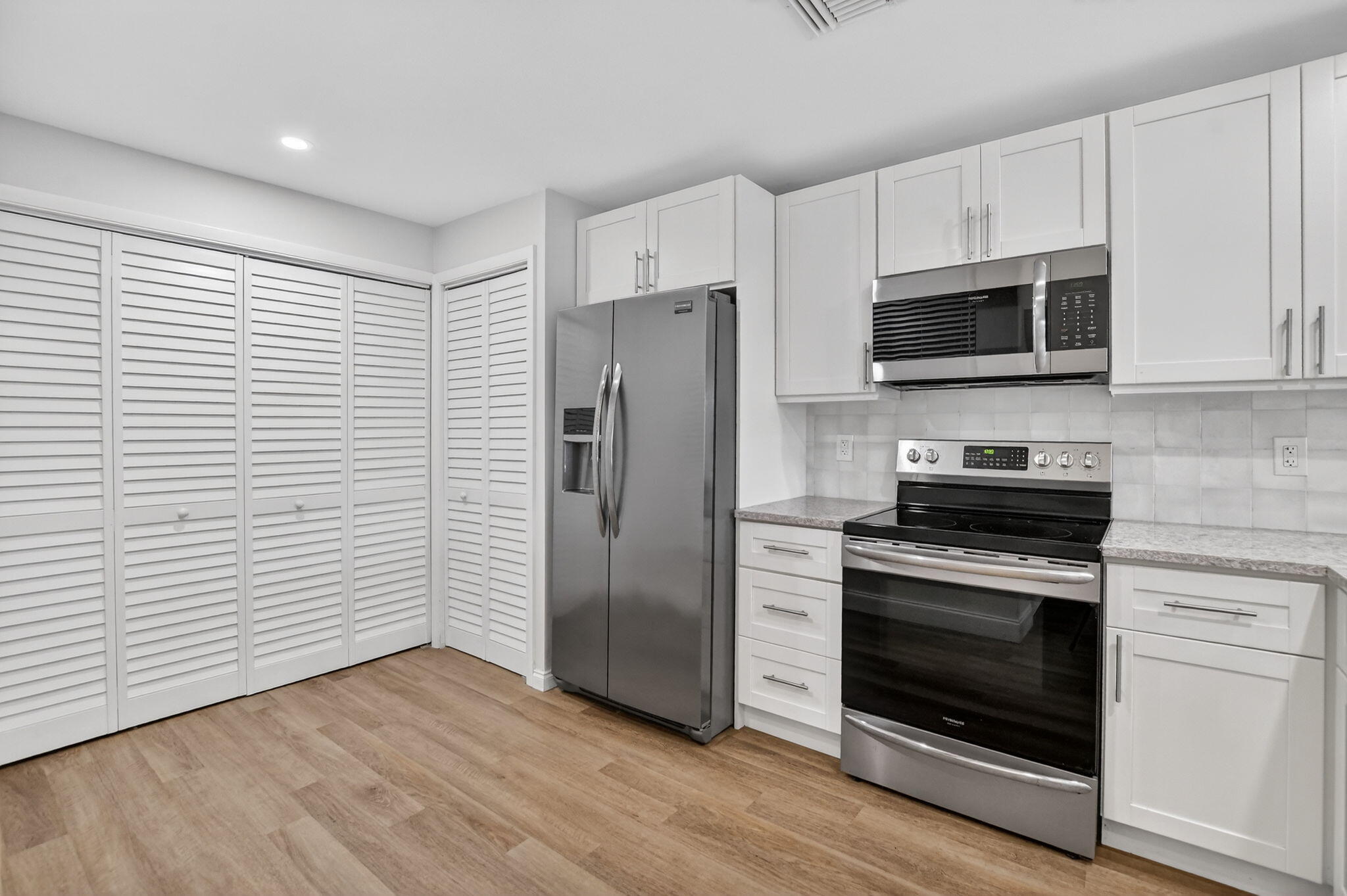 7472 La Paz Boulevard, Unit 304 Boca Raton, FL 33433 - Photo 10 of 36 a kitchen with stainless steel appliances a stove microwave and a refrigerator