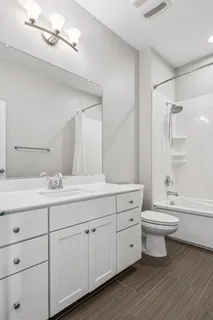 a bathroom with a double vanity sink toilet and shower