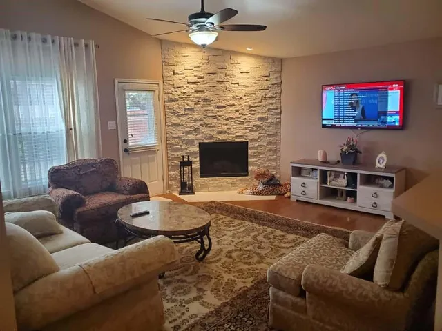 a living room with furniture a large window and a fireplace