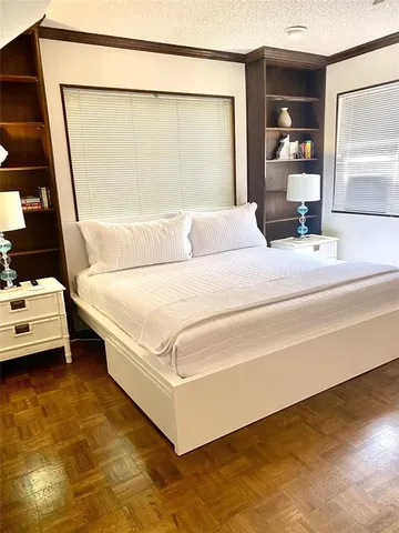 a bedroom with a bed and a large mirror on the dresser