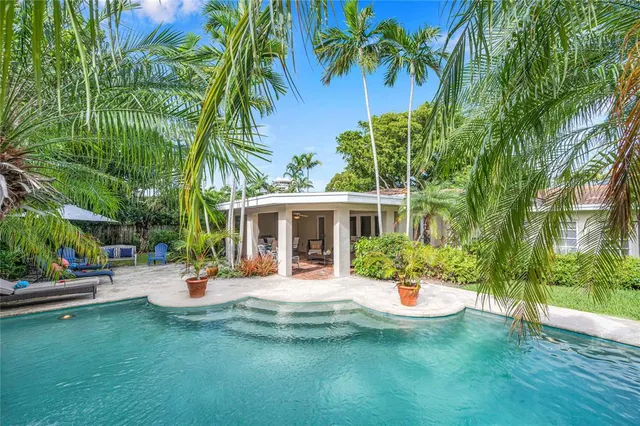 a view of a house with swimming pool and sitting area