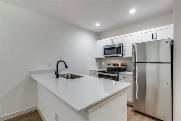 a kitchen with stainless steel appliances granite countertop a refrigerator a sink a stove a microwave and cabinets