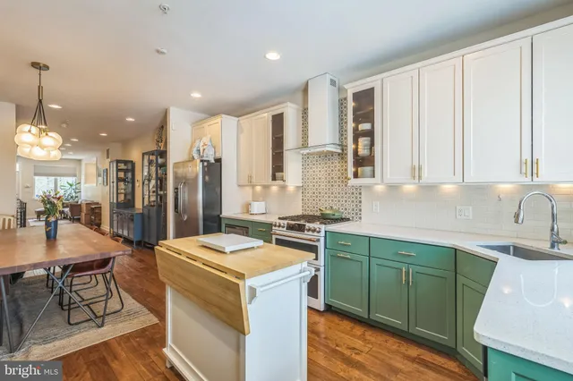 a kitchen that has a sink a stove and chairs