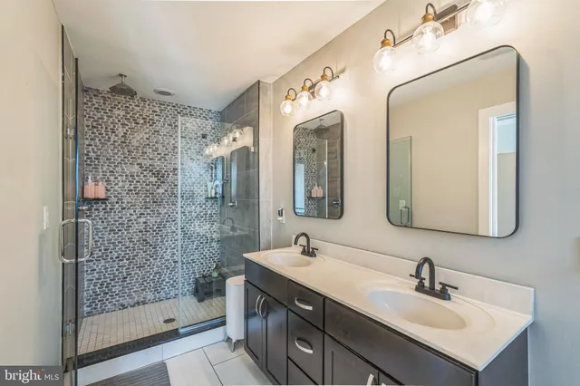 a bathroom with a double vanity sink mirror and shower