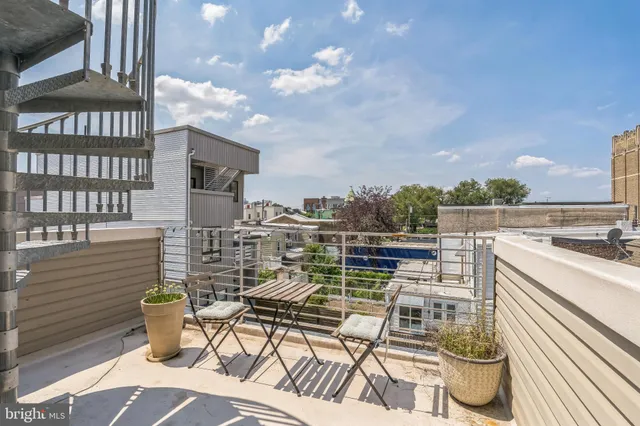 a view of a terrace with chairs and iron fence