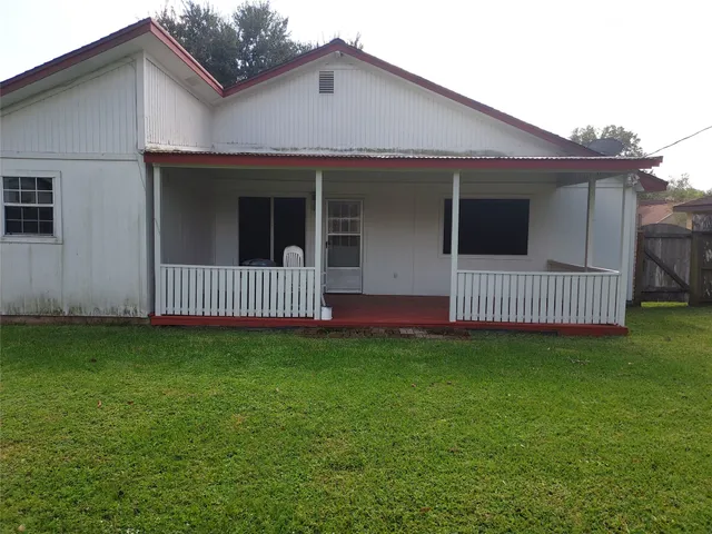 a view of a house with a yard and deck